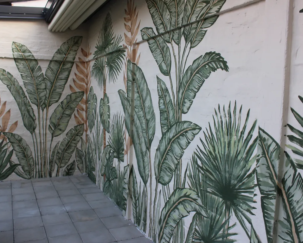 Biljni mural koji se nastavlja duž zida dvorišne terase