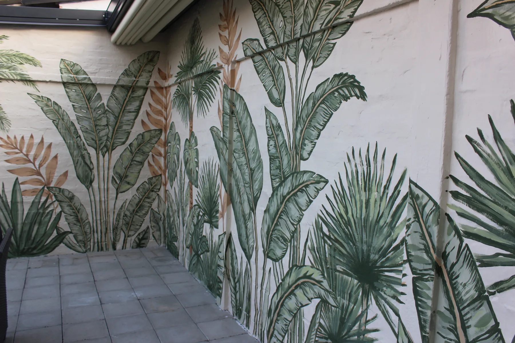 Botanical mural extending along the backyard terrace wall