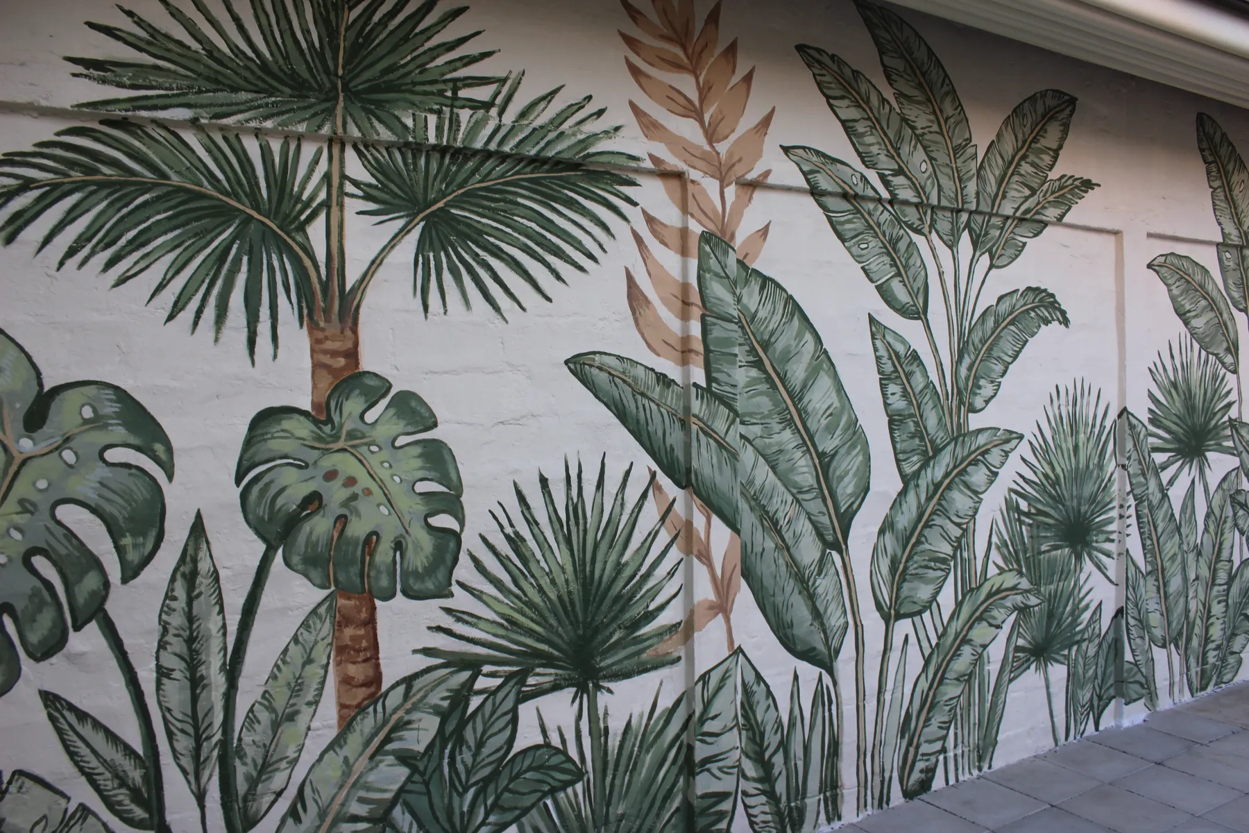 Wide view of the painted wall with palms and large leaves